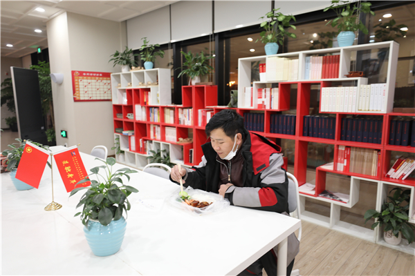 意外滯留在園區內的快遞小哥收到了青年志愿者送來的一份熱騰騰晚餐，讓這個冬雪夜更暖心.jpg